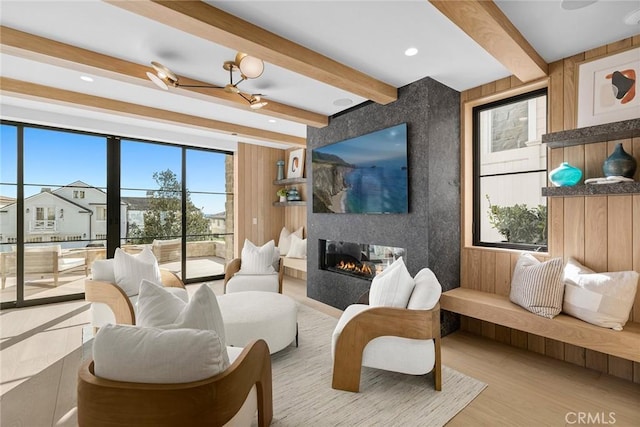 living room featuring a fireplace, beamed ceiling, and wood finished floors