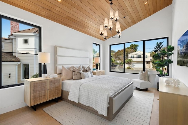 bedroom with baseboards, wood ceiling, light wood-style flooring, vaulted ceiling, and a chandelier