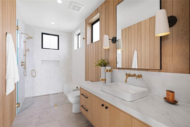 bathroom with toilet, a shower with door, and vanity