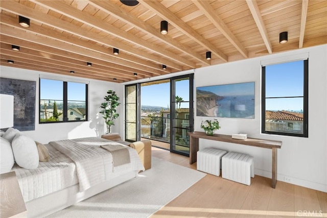 bedroom featuring beamed ceiling, wooden ceiling, wood finished floors, and access to exterior