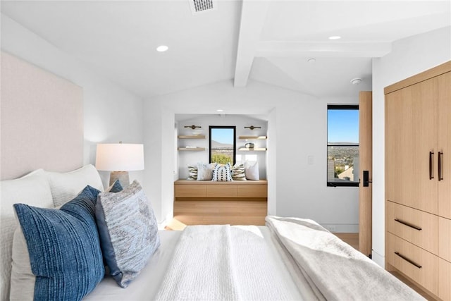 bedroom with visible vents, lofted ceiling with beams, and light wood finished floors