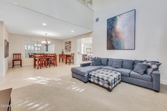 carpeted living room featuring an inviting chandelier