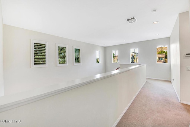 hallway with light colored carpet