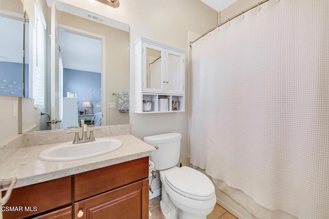 bathroom with toilet, vanity, and tile patterned flooring