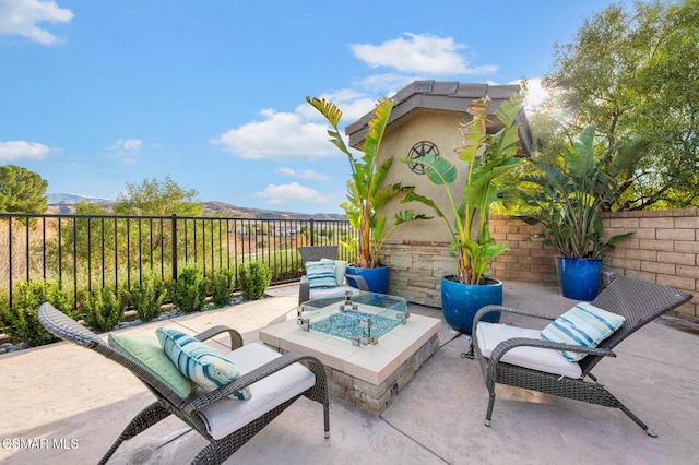 view of patio / terrace with a mountain view and an outdoor fire pit