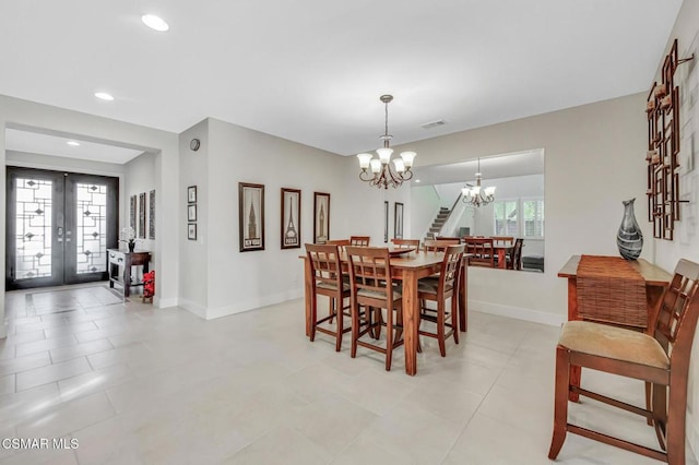 dining space featuring a chandelier and french doors