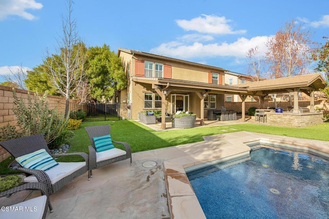 rear view of house featuring an outdoor kitchen, exterior bar, outdoor lounge area, and a patio