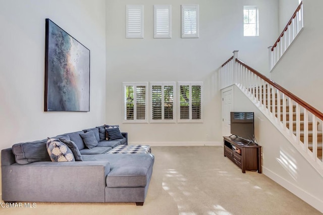 living room featuring light carpet and a towering ceiling