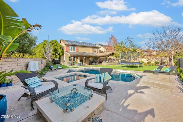 view of swimming pool featuring a trampoline, a patio area, and an in ground hot tub