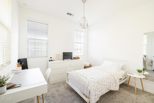 carpeted bedroom with a chandelier