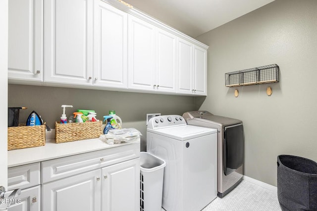 laundry room with light tile patterned flooring, independent washer and dryer, and cabinets