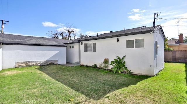 rear view of house featuring a yard