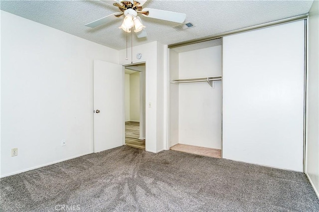 unfurnished bedroom with ceiling fan, a textured ceiling, a closet, and carpet