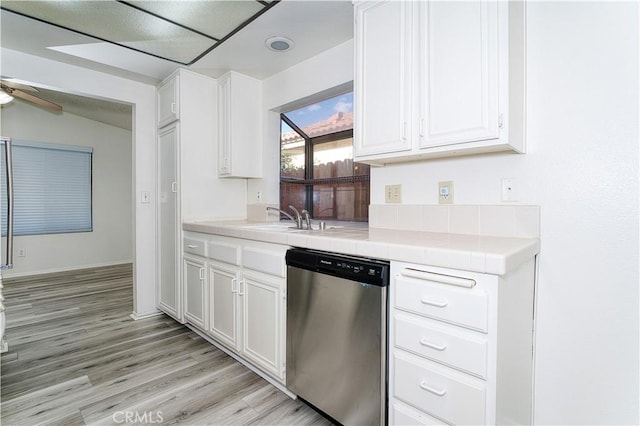 kitchen featuring ceiling fan, dishwasher, sink, tile counters, and white cabinets