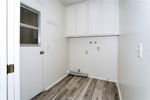 clothes washing area featuring light hardwood / wood-style floors, hookup for a washing machine, gas dryer hookup, and cabinets