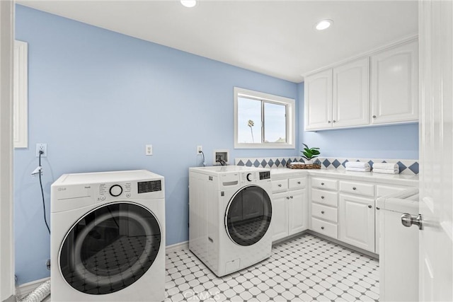 washroom with washer and clothes dryer and cabinets