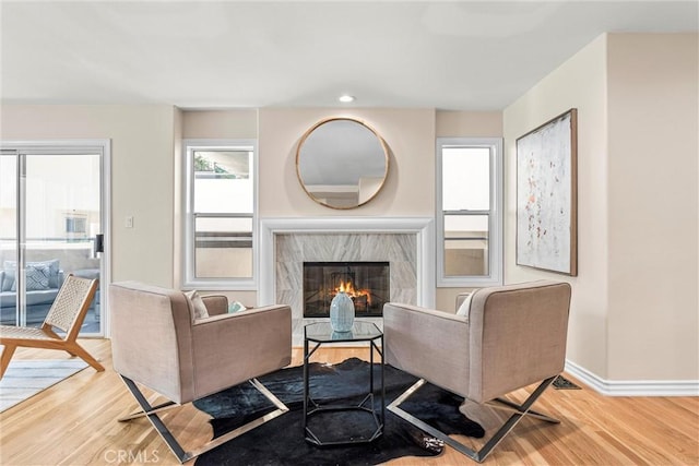 living room featuring a premium fireplace and light hardwood / wood-style flooring