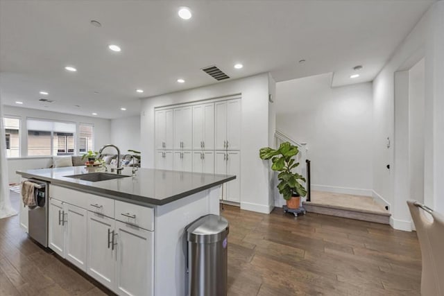 kitchen with white cabinetry, dark hardwood / wood-style flooring, sink, a kitchen island with sink, and stainless steel dishwasher