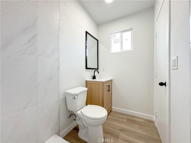 bathroom featuring hardwood / wood-style flooring, toilet, and vanity