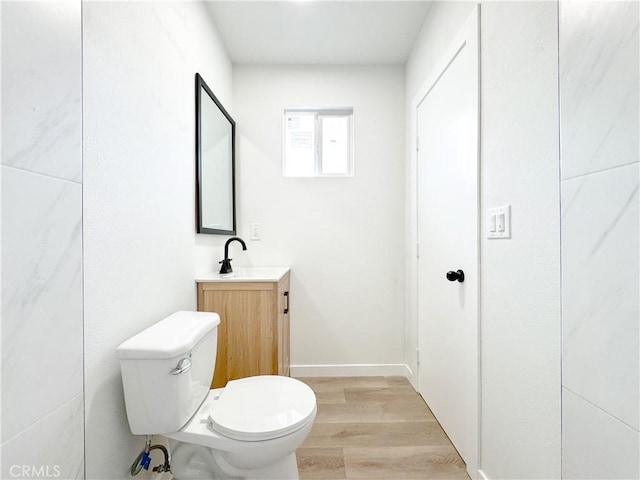 bathroom with wood-type flooring, toilet, and vanity