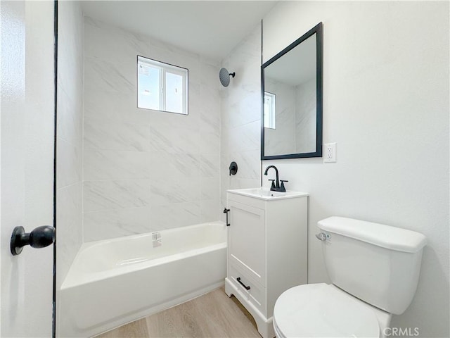 full bathroom with toilet, vanity, wood-type flooring, and tiled shower / bath combo