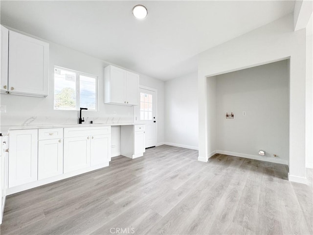 kitchen with light hardwood / wood-style floors, sink, and white cabinetry