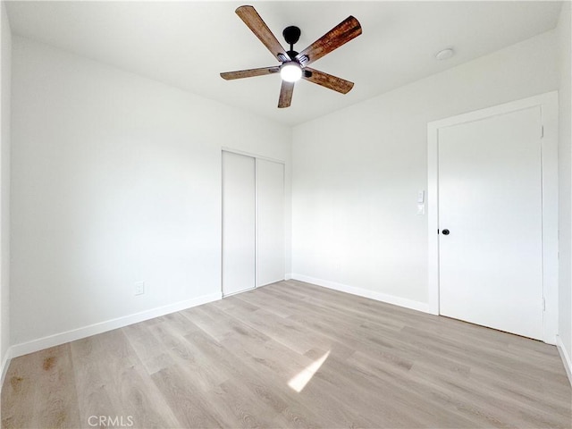 unfurnished bedroom with ceiling fan, a closet, and light hardwood / wood-style flooring