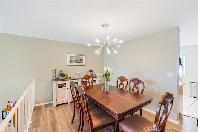 dining area with an inviting chandelier and light hardwood / wood-style flooring