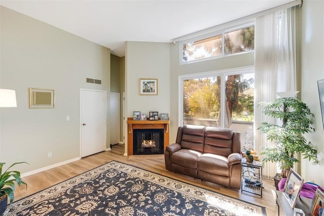 living room with light hardwood / wood-style floors and a high ceiling