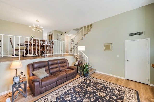 living room featuring light wood-type flooring and an inviting chandelier