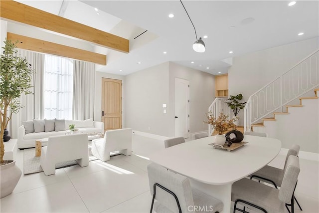 tiled dining area featuring beam ceiling