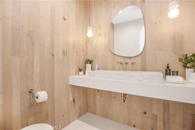 bathroom with sink and wooden walls