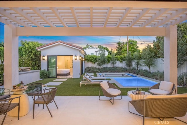 patio terrace at dusk with a lawn, a pergola, and an outdoor structure