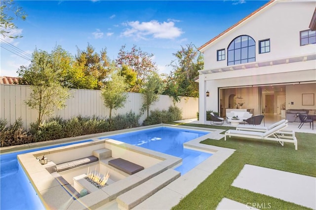 view of pool featuring a patio, a lawn, and an outdoor living space with a fire pit