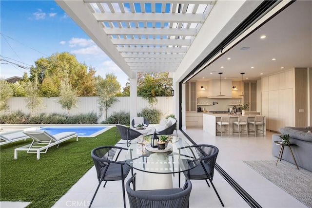 view of patio / terrace with a fenced in pool, a pergola, and a bar