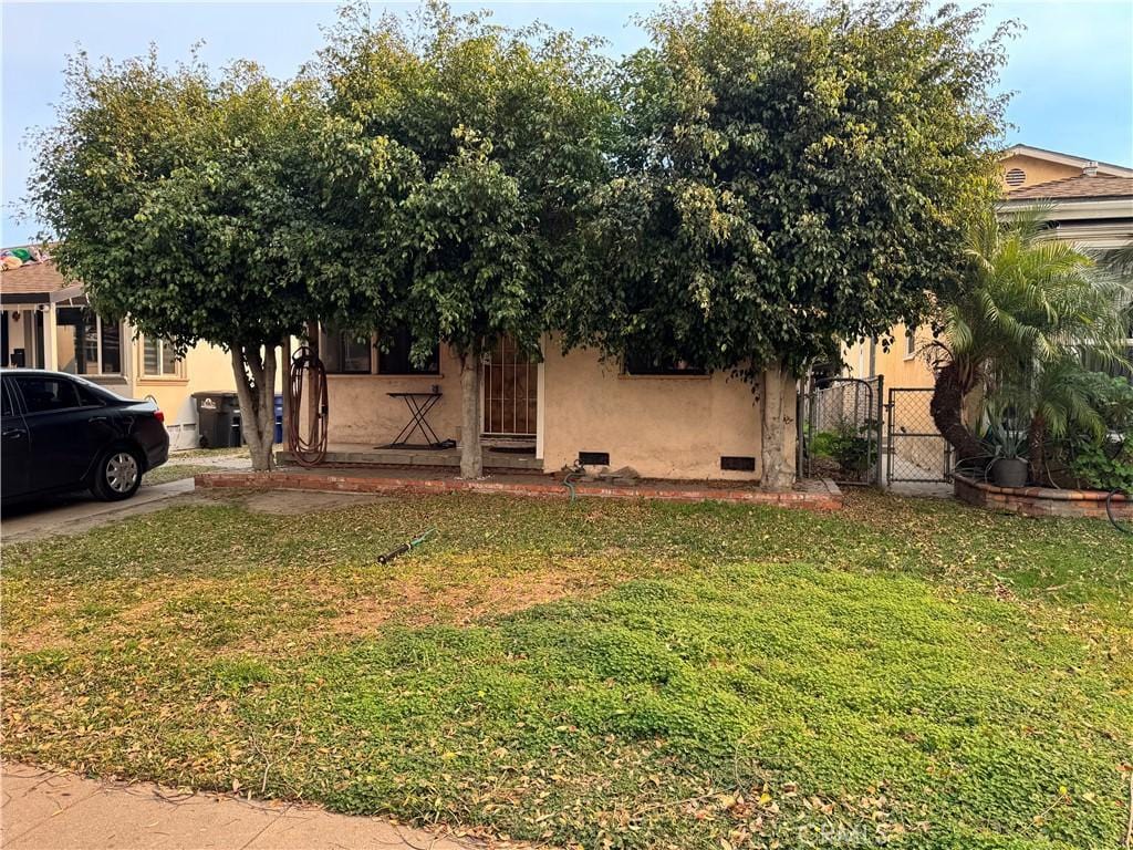 view of property hidden behind natural elements with a front lawn