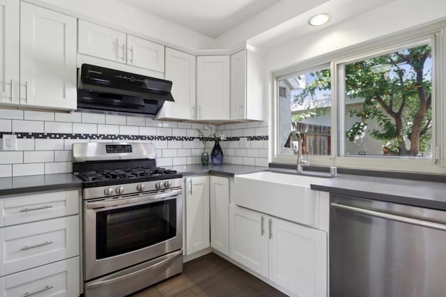 kitchen with appliances with stainless steel finishes, decorative backsplash, white cabinets, and sink