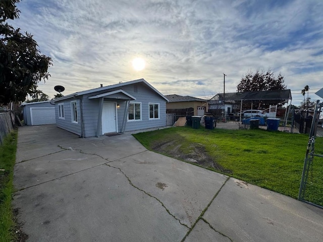 single story home with a garage, a front lawn, and an outdoor structure