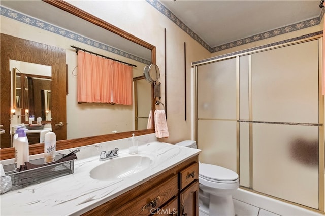 bathroom with an enclosed shower, vanity, toilet, and tile patterned flooring