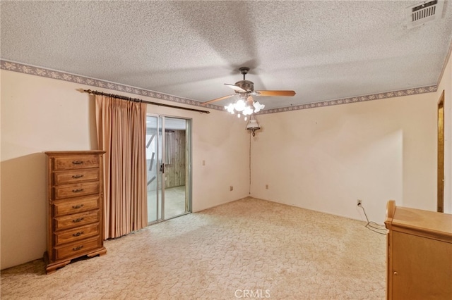 carpeted spare room featuring ceiling fan and a textured ceiling