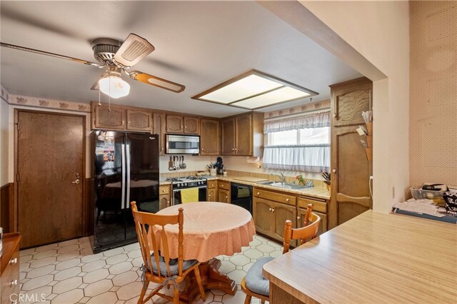 kitchen with black appliances, ceiling fan, and sink