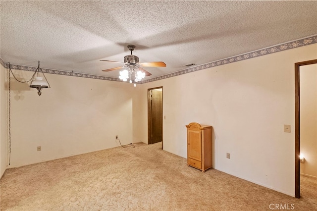 carpeted spare room with a textured ceiling and ceiling fan