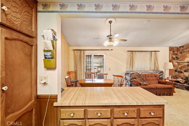 kitchen featuring ceiling fan and wooden walls