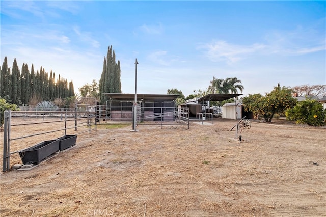 view of yard with a rural view and an outdoor structure