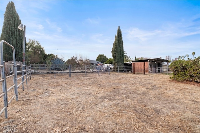 view of yard featuring a rural view and an outdoor structure