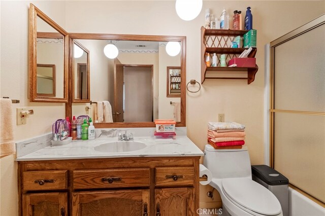 full bathroom with toilet, vanity, and combined bath / shower with glass door