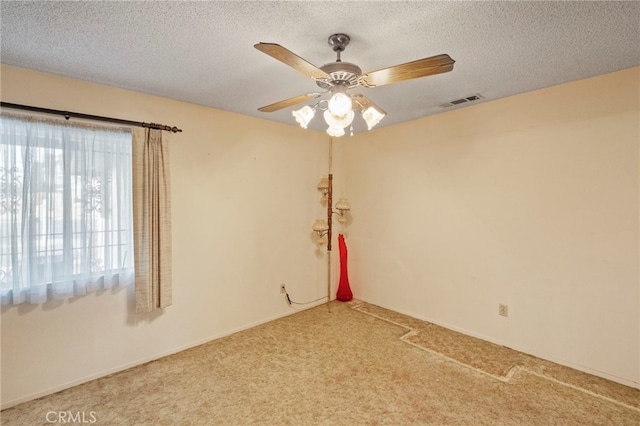 carpeted spare room with ceiling fan and a textured ceiling