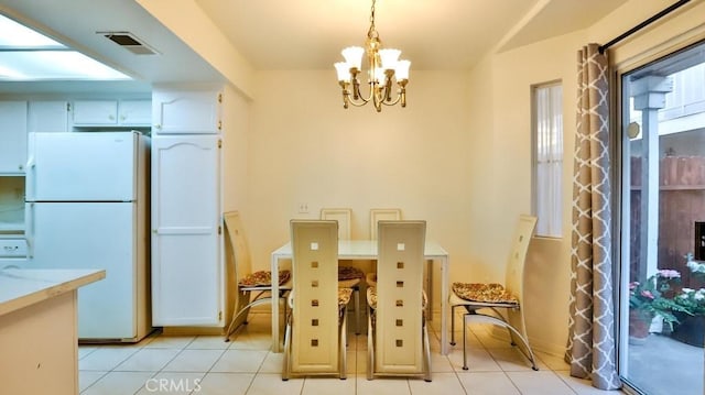 dining space with light tile patterned floors and an inviting chandelier