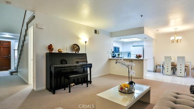 carpeted living room featuring sink and a notable chandelier