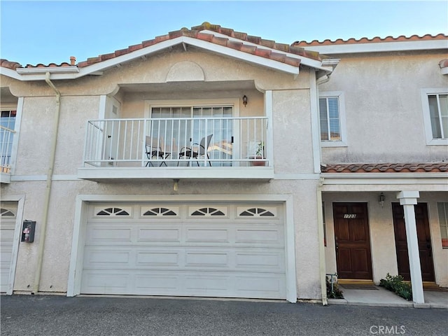 multi unit property with a balcony and a garage